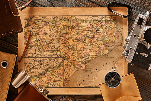 Vintage old 35mm camera on wooden background with antique XIX century map