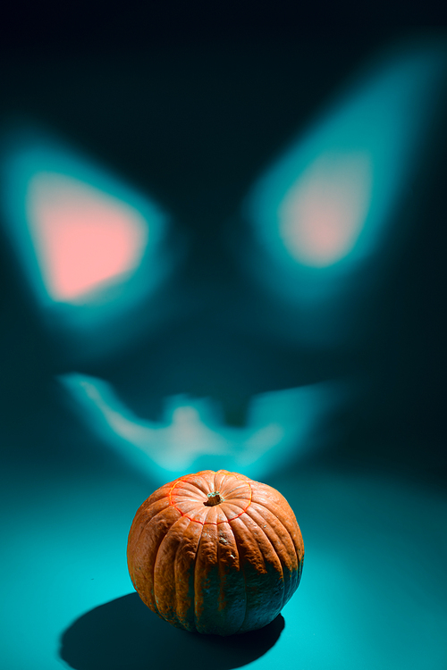Halloween smile. Projection of glowing Halloween pumpkin lantern with Jack o'Lantern face on wall
