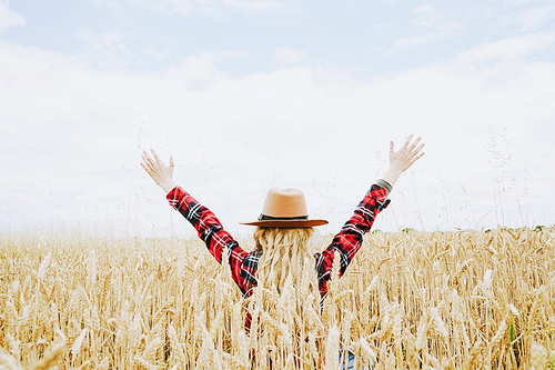 Young cowgirl in a field of cereals
