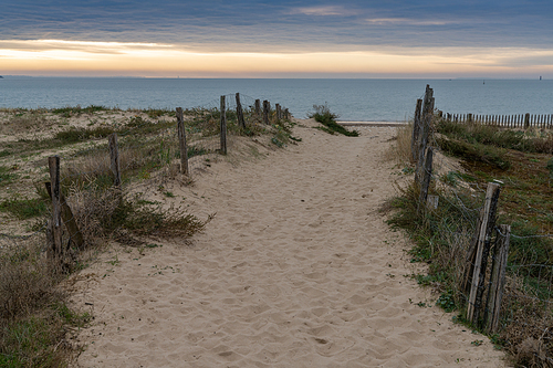 A secluded beach access at sunrise with a view of the ocean