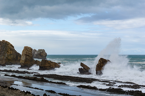 A rocky and wild coast with stormy waves hitting the shore