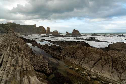 A rocky and wild coast with stormy waves hitting the shore