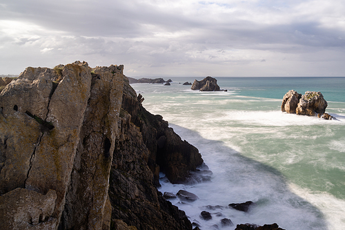 A rocky and wild coast with stormy waves hitting the shore