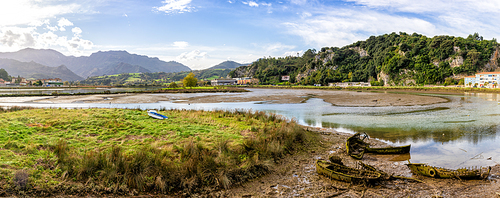 A view of the estuary of the Sella River in Asturias at low tide with old row boat wrecks