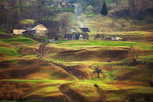 Foggy spring morning in mountain village. Fields and hills