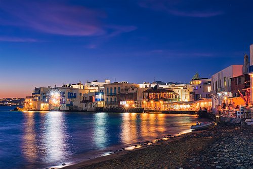 Harbor and colorful waterfront houses of Little Venice romantic spot illuminated in night. Mykonos townd, Greece