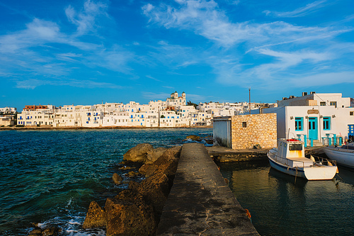 Picturesque view of Naousa town in famous tourist attraction Paros island, Greece with traditional whitewashed houses and moored fishing boats on sunset