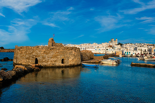 Picturesque view of Naousa town in famous tourist attraction Paros island, Greece with traditional whitewashed houses and small venetian castle fort
