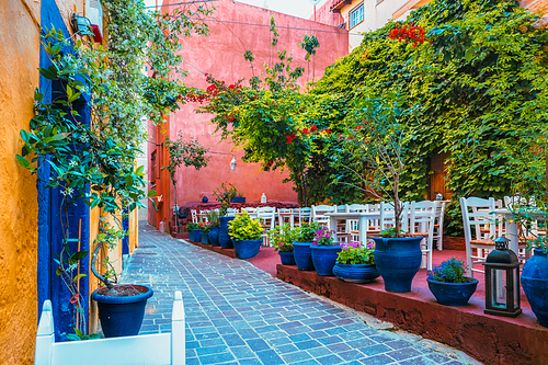 Street cafe in scenic picturesque streets of Chania venetian town with coloful old houses. Chania greek village in the morning. Chanica, Crete island, Greece