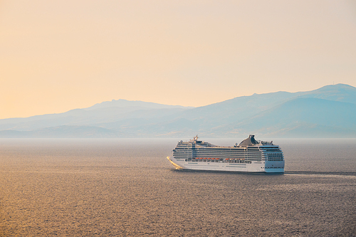 Cruise ship in Aegean sea on sunset. Mykonos island, Greece