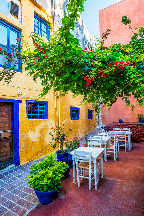 Street cafe in scenic picturesque streets of Chania venetian town with coloful old houses. Chania greek village in the morning. Chanica, Crete island, Greece