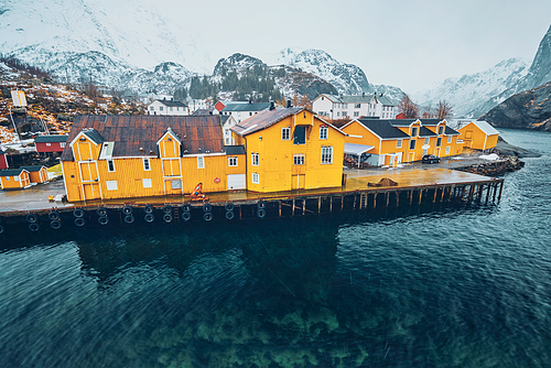 Nusfjord authentic fishing village with yellow rorbu houses in Norwegian fjord in winter. Lofoten islands, Norway