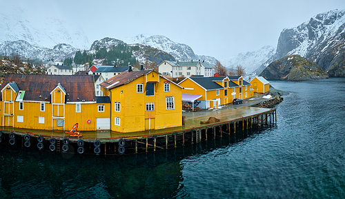 Nusfjord authentic fishing village with yellow rorbu houses in Norwegian fjord in winter. Lofoten islands, Norway