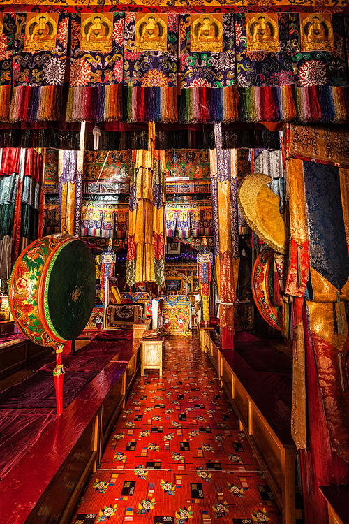 Inside Spituk Gompa Tibetan Buddhist monastery prayer hall with drums. Ladakh, India