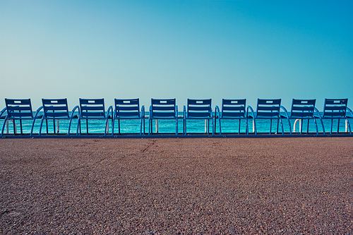 Famous blue chairs bench on beach in the morning. Nice, France