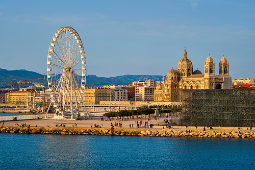 View of Grande Roue de Marseille - Ferris wheel and Marseille cathedral and port of Marseille on sunset. Marseille, France