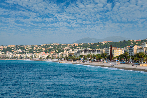 Picturesque scenic view of Mediterranean sea coast in Nice, France. Mediterranean Sea waves surging on the coast, people are relaxing on the beach. Nice, France