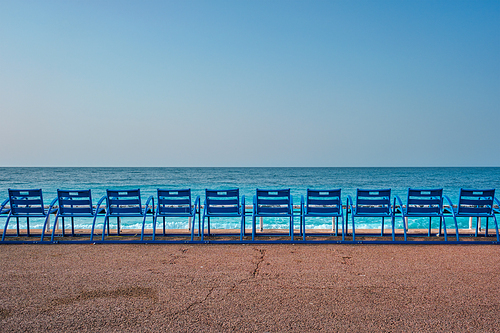 Famous blue chairs bench on beach in the morning. Nice, France