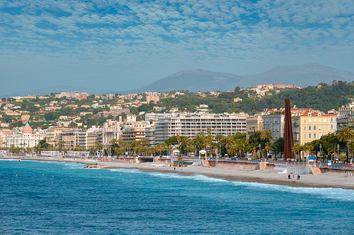 Picturesque scenic view of Mediterranean sea coast in Nice, France. Mediterranean Sea waves surging on the coast, people are relaxing on the beach. Nice, France