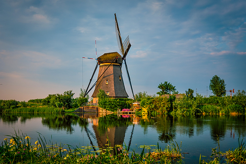 Netherlands rural lanscape with windmills at famous tourist site Kinderdijk in Holland on sunset with dramatic sky