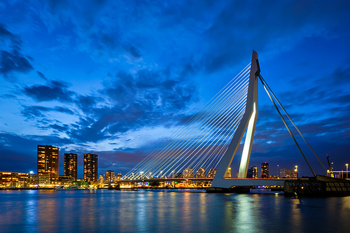 View of Erasmus Bridge (Erasmusbrug) and Rotterdam skyline cityscape illuminated at night. Rotterdam, Netherlands
