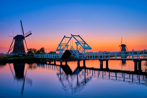 Netherlands rural lanscape with windmills and bridge at famous tourist site Kinderdijk in Holland in twilight