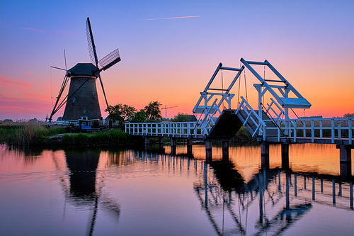 Netherlands rural lanscape with windmills and bridge at famous tourist site Kinderdijk in Holland in twilight