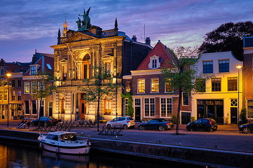 Canal with boats and houses illuminated in the evening. Haarlem, Netherlands