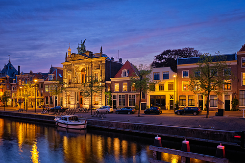 Canal with boats and houses illuminated in the evening. Haarlem, Netherlands