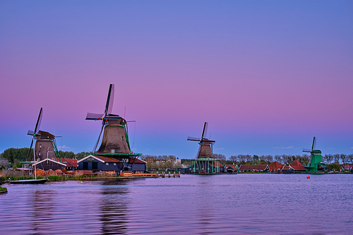 Windmills at famous tourist site Zaanse Schans in Holland in twilight after sunset. Zaandam, Netherlands