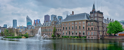 Panorama of the Binnenhof House of Parliament and the Hofvijver lake with downtown skyscrapers in background. The Hague, Netherlands