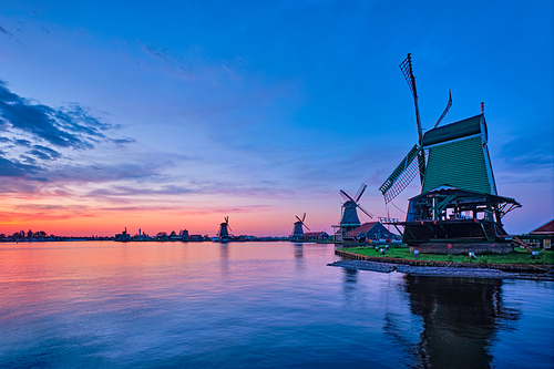 Netherlands rural scene - windmills at famous tourist site Zaanse Schans in Holland on sunset with dramatic sky. Zaandam, Netherlands