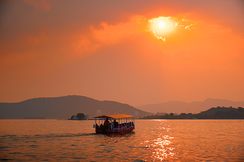 Tourist boat in lake Pichola on sunset. Udaipur, Rajasthan, India