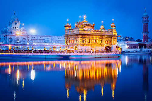 Sikh sacred site gurdwara Sri Harmandir Sahib (also known as The Golden Temple, also Darbar Sahib) illuminated at night. Amritsar, Punjab state, India