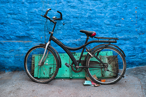 Old bicycle at the wall of blue house in streets of of Jodhpur, also known as Blue City due to the vivid blue-painted Brahmin houses, Jodhpur, Rajasthan, India