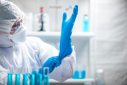 medicine specialist wearing PPE suit setting, medical people wearing surgical glove, face mask, and goggle to protection to work with coronavirus flu in hospital laboratory