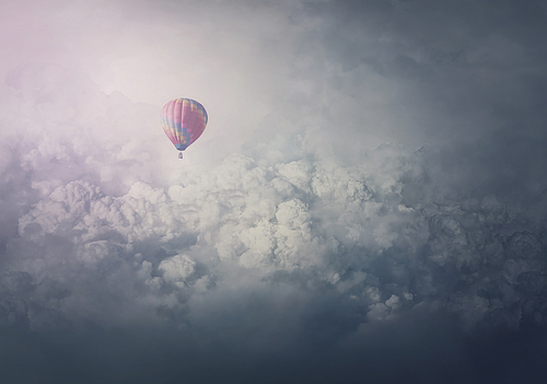 Wonderful adventure, epic scene with a hot air balloon flying over the clouds. Fabulous minimalist view, airship floating in the sky. Travel and journey concept. Inspirational cloudscape scenery