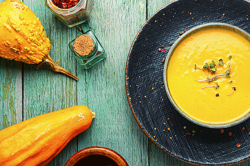 Homemade vegetarian pumpkin cream soup.Pumpkin soup on wooden rustic table.Autumn soup