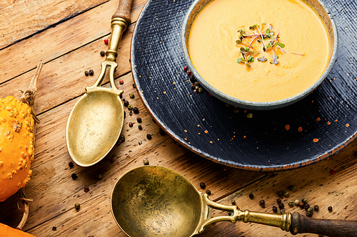 Homemade vegetarian pumpkin cream soup.Pumpkin soup on wooden rustic table.Autumn soup