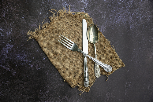 Flat lay image of vintage cutlery on textured rough background