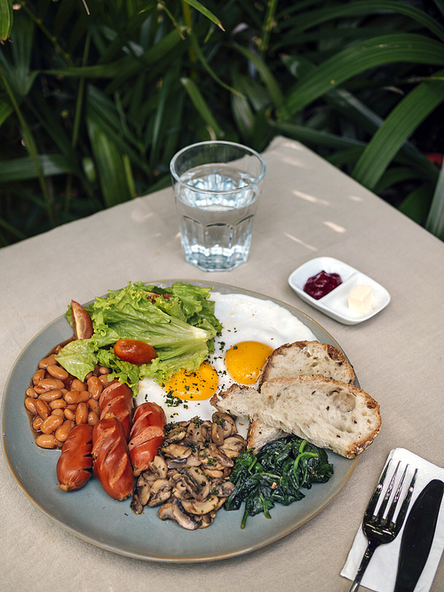 Big American breakfast with two eggs, mushroom, bean, sausages.