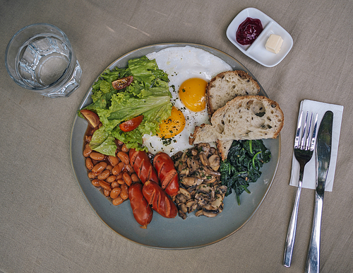 Big American breakfast with two eggs, mushroom, bean, sausages.