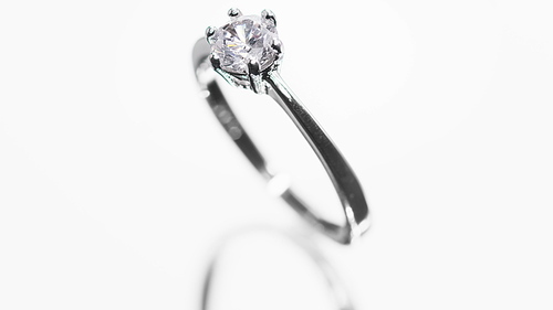 Engagement diamond ring rotating on white background. Traditional piece of jewelry, macro shot. Seamless loop.