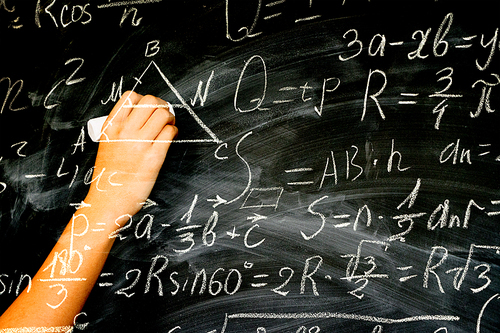 Hand with chalk writting on math formulas black board, double exposure