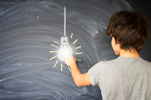 Teenager boy finding an idea with glowing bulb - back to school education concept