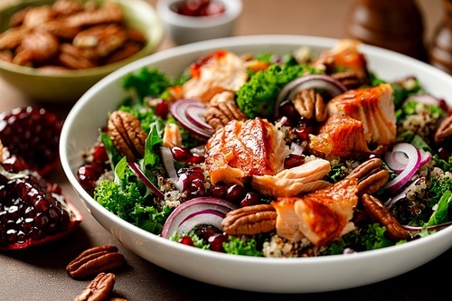 Salmon superfood salad with grilled fish, kale, quinoa, pecan nuts, red onion and pomegranate