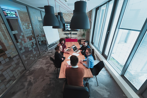 Top view of young multi-ethnic business people working and communicating together in creative office. Selective focus. High-quality photo