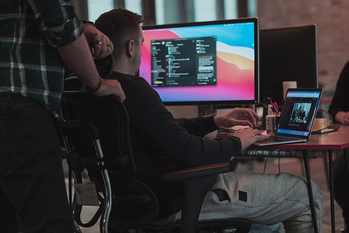 A photo of three men staring intently at a computer while sitting in a modern office. Selective focus. High-quality photo