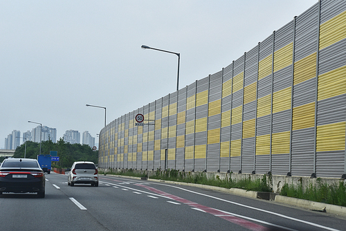 도시주변의 고속도로,순환도로,간선도로 주변의 거주자들을 위한 소음차단벽인 방음벽이 있는 풍경