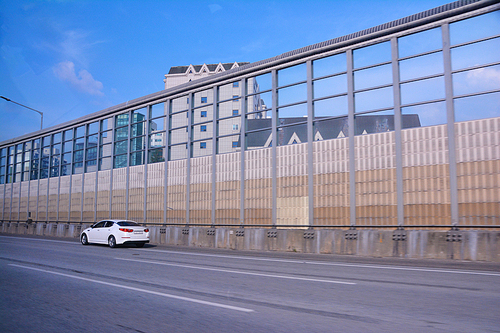 도시주변의 고속도로,순환도로,간선도로 주변의 거주자들의 소음공해를 방지하기위해 설치한 소음차단벽인 방음벽이 있는 풍경